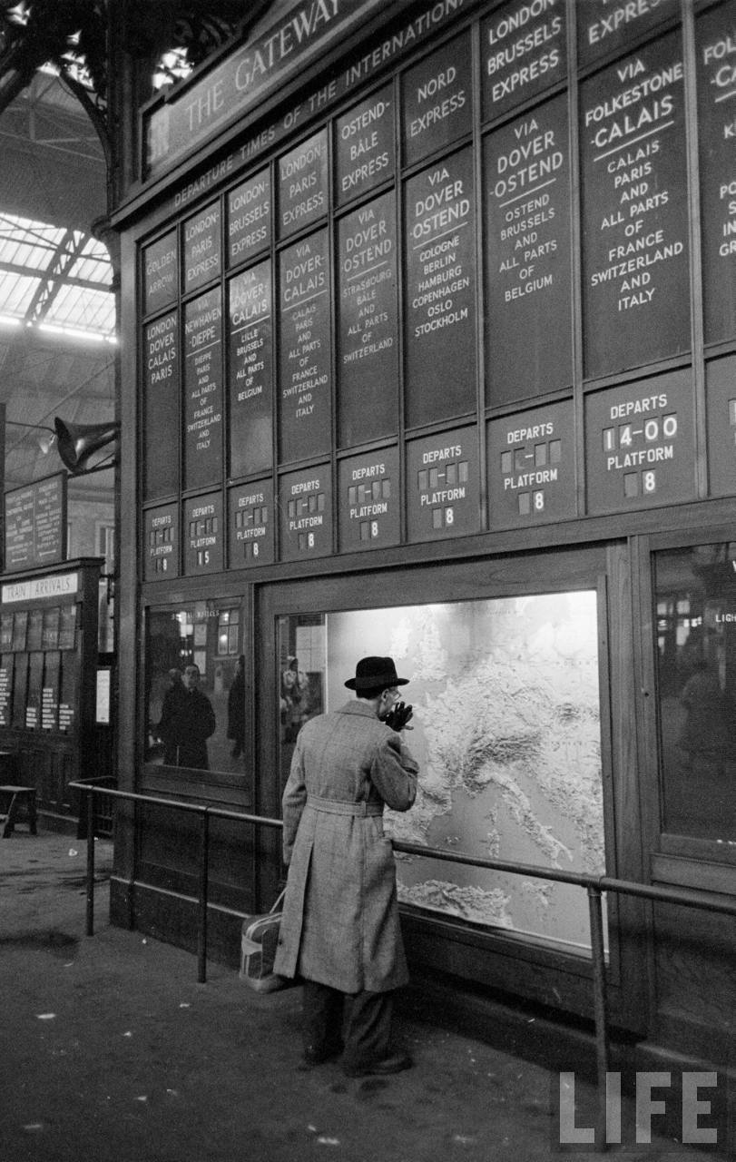 Reisgenoot Roy Rowan bij het international departures-bord | Foto: Jack Birns, 1950